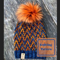 an orange and blue knitted hat with a pom - pom on top