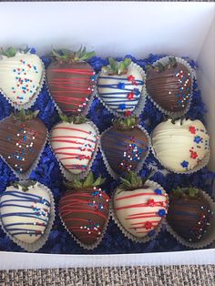 twelve chocolate covered strawberries in a box with blue ribbon and sprinkles