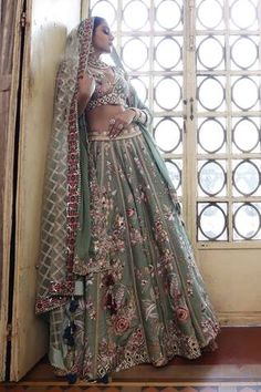 Sage green silk 24 kali lehenga with abstract floral pattern thread work and zari embroidery. Paired with an embroidered padded choli and dupatta.
Components: 3
Pattern: Embroidered
Type Of Work: Thread, Zari
Neckline: V Neck
Sleeve Type: Cap
Fabric: Lehenga and Choli: Silk, Dupatta: Organza
Color: Green
Other Details: 
Lehenga length: 43 inches
Occasion: Wedding, Mehendi and Haldi - Aza Fashions Designer Green Lehenga For Transitional Season, Transitional Green Lehenga With Resham Embroidery, Green Lehenga With Resham Embroidery For Transitional Season, Transitional Green Lehenga With Dupatta, Green Traditional Wear For Reception With Meenakari, Reception Green Traditional Wear With Meenakari, Green Meenakari Sets For Festivals, Transitional Green Lehenga With Intricate Embroidery, Green Floor-length Lehenga For Transitional Season