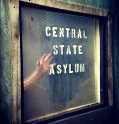 a sign that says central state asylm on the side of a building in front of a window