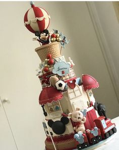 a cake made to look like a train with mickey mouses on top and balloons