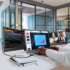 a person sitting at a desk with two monitors and a laptop on their lap top