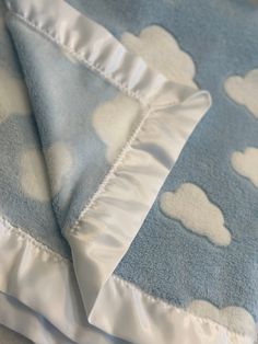 two blue and white baby blankets with clouds on them