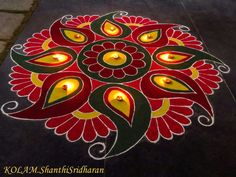 a decorated floor with lit candles in the shape of a flower and leaves on it