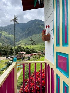 a balcony with flowers and mountains in the background