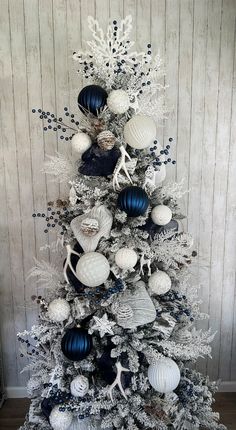 a white christmas tree with blue and silver ornaments