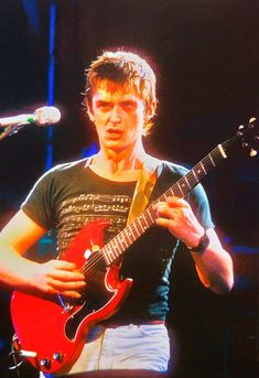 a young man playing an electric guitar on stage