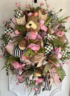 a wreath with teddy bears and flowers on the front door