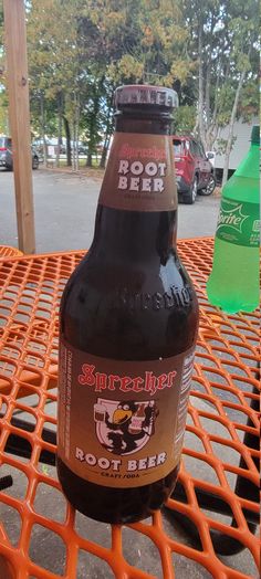 a beer bottle sitting on top of an orange grate