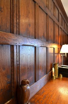 a wood paneled room with a lamp on the table and an owl figurine