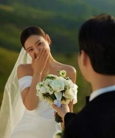 a woman in a wedding dress standing next to a man