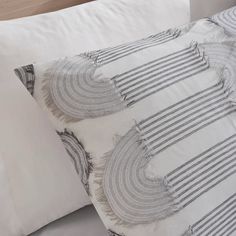 two white pillows sitting next to each other on a bed