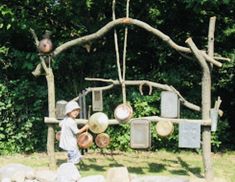 a man standing in front of a wooden structure with pots and pans on it