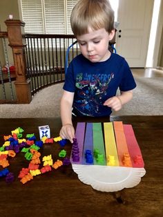 a young boy is playing with legos on the table