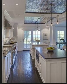 a large kitchen with wooden floors and white cabinets