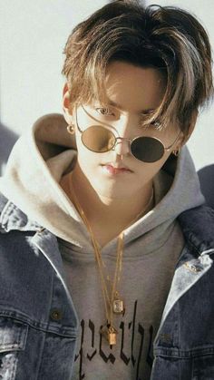 a boy wearing sunglasses and a hoodie looks off to the side with his eyes closed