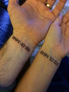 two people holding hands with tattoos on their wrists and the words in roman numerals