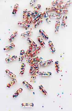 colorful sprinkles are scattered on a white surface