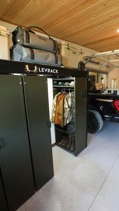 a garage with two black metal lockers next to each other and luggage in the back