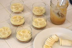 banana slices and sliced bananas sitting on a table next to cups with liquid in them