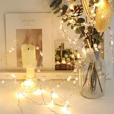 a vase filled with flowers sitting on top of a table next to a lit candle