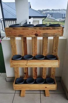 a wooden shelf with cups on it in front of a building