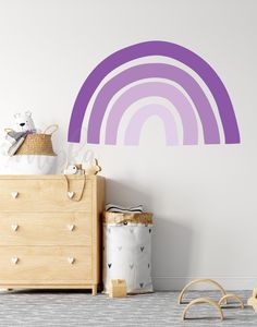 a child's room with a wall decal that has a rainbow painted on it