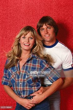 a young man and woman posing for a studio portrait with their arms around each other