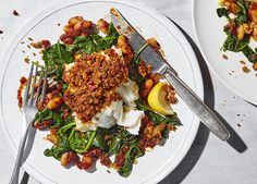 a white plate topped with meat and veggies next to a knife and fork