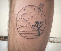 a man with a tattoo on his leg that has a tree and moon in it