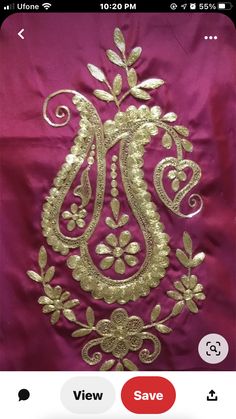 an applique on the back of a pink dress with gold embroidery and leaves