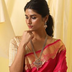 Description: A sculptural form of an antique necklace takes inspiration from the temples of India and translates it into a dressy pair to adorn. The hue of antique gold adds up a sparkle with the CZ stones along with the pearl drops at the base enhance the beauty of the piece. Making its presence felt with any outfit this one is worth making an on-trend statement. Details & Specifications: Materials used: Brass Alloy with Antique Plating Weight – Necklace 84 gm, Earrings 25 gm Length – Necklace Ruby Temple Necklace, Ceremonial Ruby Bridal Necklace In Temple Jewelry Style, Ceremonial Ruby Bridal Necklace In Temple Style, Temple Jewelry Pearl Necklace With Pendant, Ceremonial Temple Jewelry Bridal Necklace With Ruby, Ceremonial Temple Jewelry Ruby Bridal Necklace, Ceremonial Temple Necklace With 17 Jewels, Festive Temple Jewelry Pearl Necklace With Pendant, Elegant Red Temple Necklace For Diwali