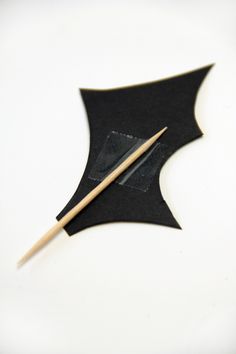 a pair of wooden chopsticks sitting on top of a black piece of paper