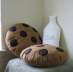 a pillow that is sitting on top of a chair with a milk bottle behind it