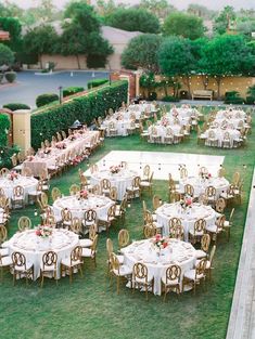 an outdoor wedding reception setup with tables and chairs set up in the middle of a lawn