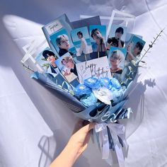 a person holding a bouquet of flowers with photos on it in front of a white background