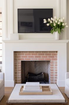 a living room with a fireplace and tv above it