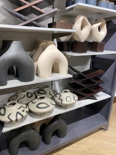 several shelves with different shapes and sizes of vases