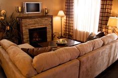 a living room filled with furniture and a flat screen tv on top of a fireplace