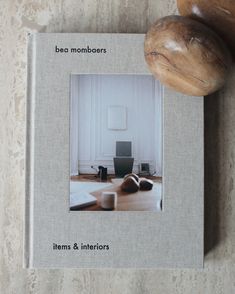 a book with an image of a room and a wooden object on the table next to it