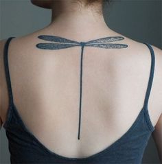 a woman with a dragonfly tattoo on her back