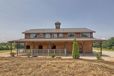 a large house with a horse pen in front of it