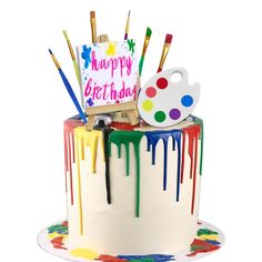 a birthday cake decorated with paint and brushes