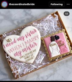 two decorated cookies in a gift box on a marble counter top, with the words mean my sister when i marry my mother