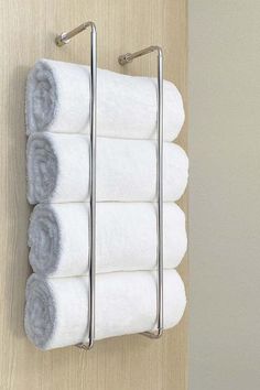 four white towels are hanging on a towel rack