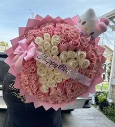 a hello kitty bouquet with pink roses in the shape of a heart