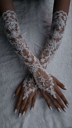 a woman's hands with white lace on them