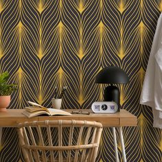 a table with a lamp, book and plant on it next to a wallpaper