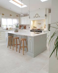 a kitchen with two stools in front of the island and an open floor plan