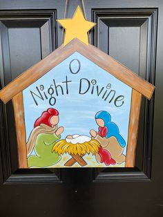 a door hanger with a nativity scene painted on it and the words night divine